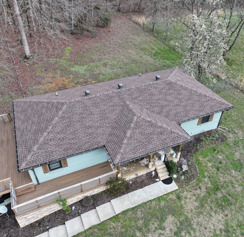 A modern house with a professionally installed, dark metal tile roof.